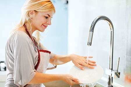 foto de uma mulher lavando prato