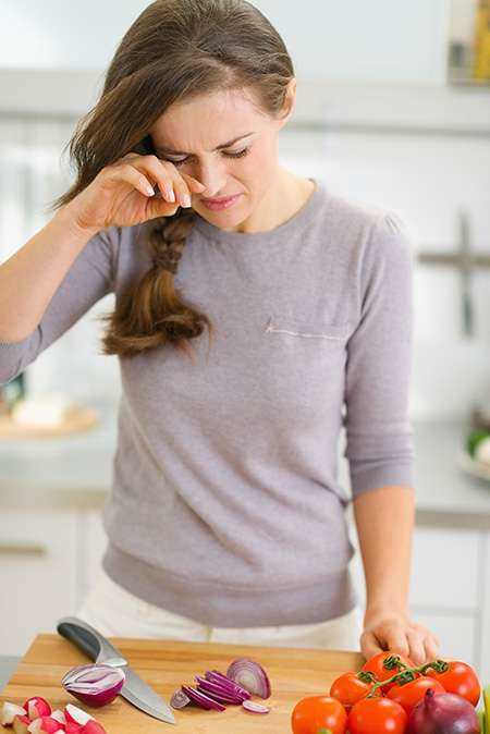 foto de mulher chorando ao cortar cebola