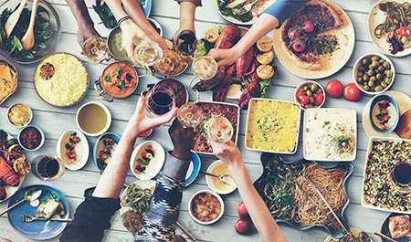 foto de uma grande mesa de jantar com pessoas brindando